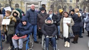 O sută de persoane cu dizabilităţi şi asistenţi sociali au protestat în Piaţa Victoriei din Capitală